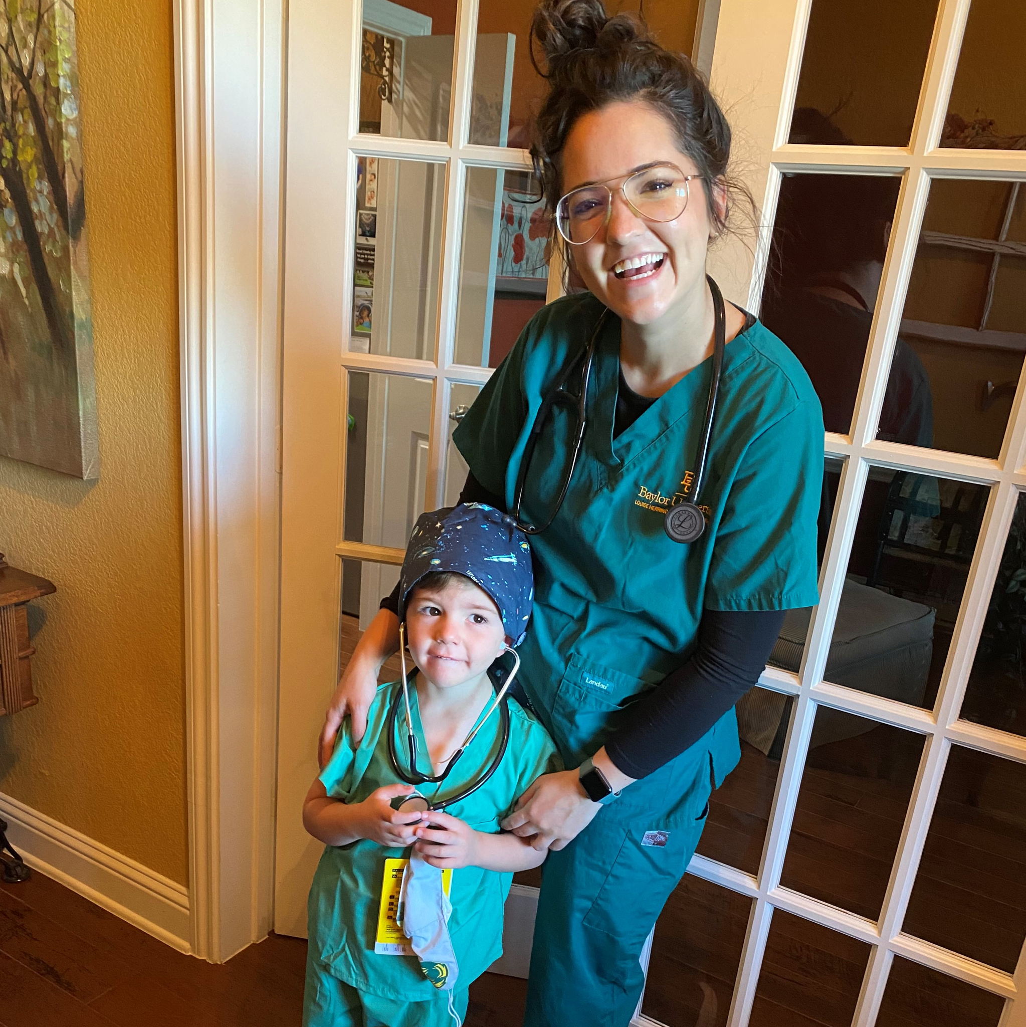 Photo of happy single mom with daughter in scrubs